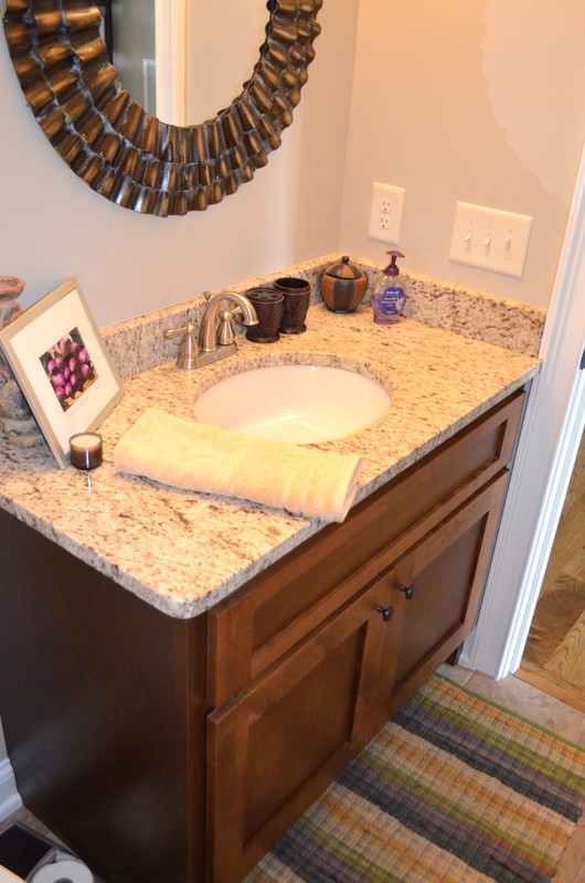 Inredning av ett klassiskt litet badrum, med ett undermonterad handfat, skåp i shakerstil, skåp i mellenmörkt trä, granitbänkskiva, blå väggar och travertin golv