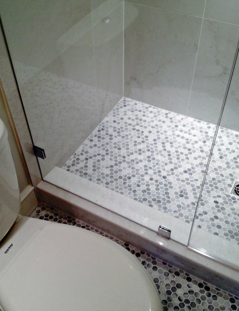 Cette image montre une salle d'eau design de taille moyenne avec une douche double, un carrelage blanc, une plaque de galets, un mur beige et un sol en carrelage de porcelaine.