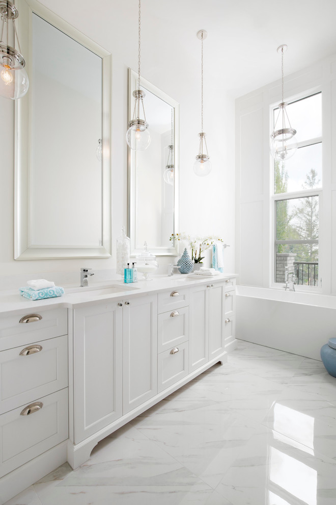 Inspiration for a medium sized traditional ensuite bathroom in Calgary with shaker cabinets, white cabinets, a freestanding bath, a one-piece toilet, white tiles, ceramic tiles, white walls, porcelain flooring, a submerged sink, quartz worktops and white worktops.
