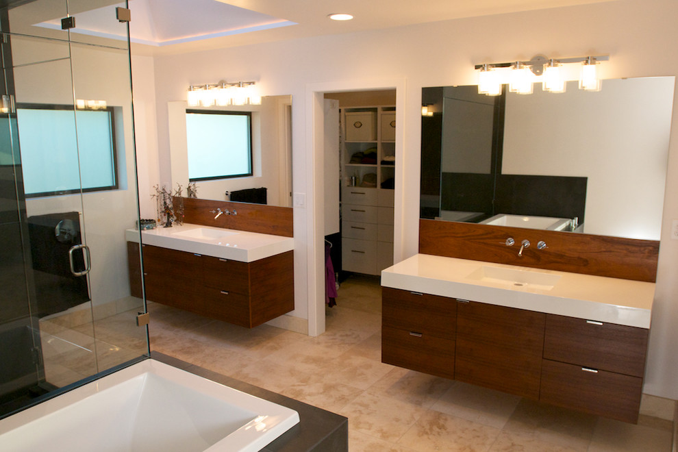 Inspiration for a large contemporary beige tile and porcelain tile travertine floor bathroom remodel in Seattle with an integrated sink, flat-panel cabinets, dark wood cabinets, a one-piece toilet, solid surface countertops and white walls