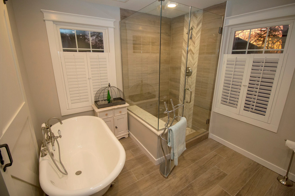 Medium sized traditional ensuite bathroom in New York with freestanding cabinets, medium wood cabinets, an alcove bath, a shower/bath combination, a one-piece toilet, brown tiles, porcelain tiles, beige walls, laminate floors, a built-in sink, quartz worktops, brown floors, an open shower and white worktops.