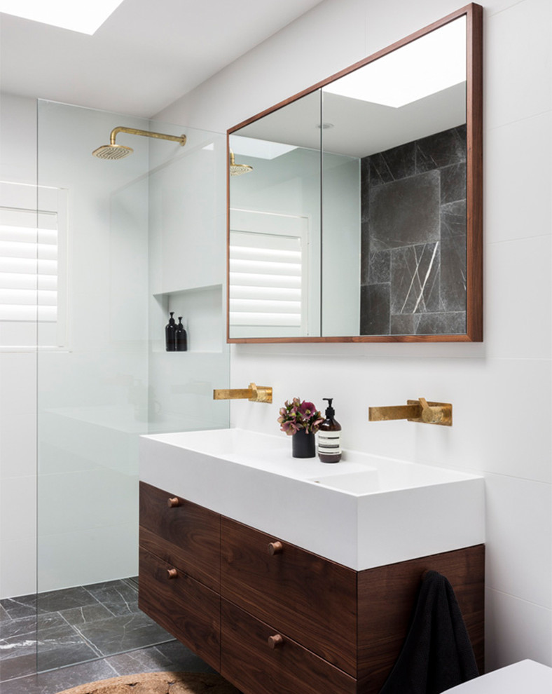 На фото: ванная комната в современном стиле с плоскими фасадами, темными деревянными фасадами, душем без бортиков, белой плиткой, белыми стенами, душевой кабиной, консольной раковиной, серым полом и открытым душем с
