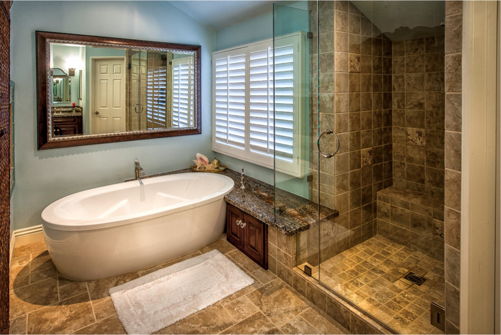 Bathroom - large mediterranean master beige tile and ceramic tile porcelain tile and beige floor bathroom idea in Orange County with shaker cabinets, dark wood cabinets, blue walls, an undermount sink, granite countertops and a hinged shower door
