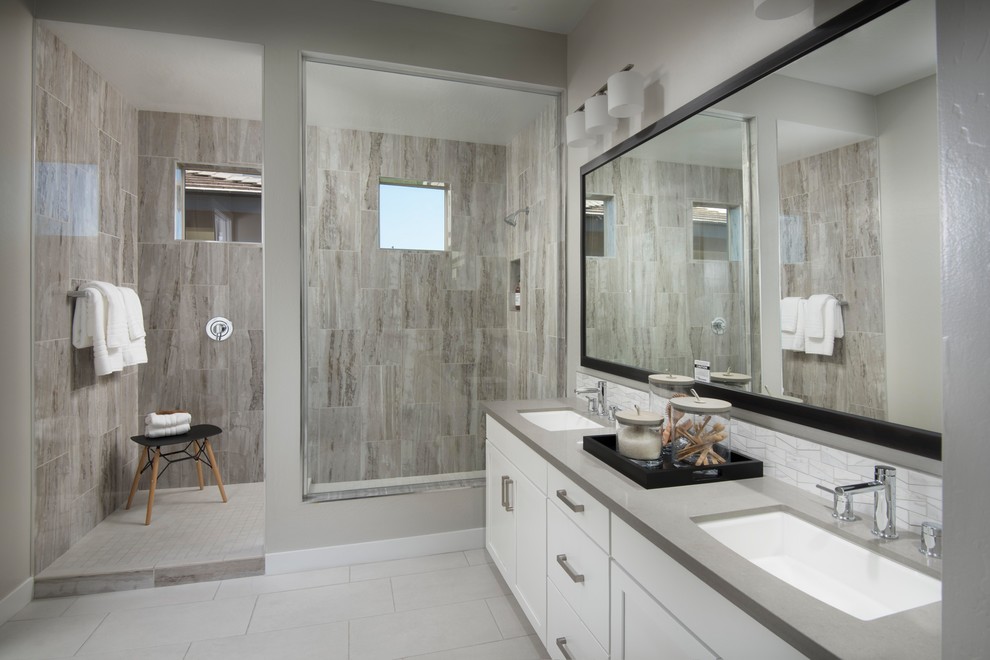 Modelo de cuarto de baño principal, contemporáneo, con armarios estilo shaker, puertas de armario blancas, ducha esquinera, baldosas y/o azulejos grises, baldosas y/o azulejos de porcelana, paredes grises, suelo de baldosas de porcelana, lavabo bajoencimera, encimera de cuarzo compacto, suelo blanco, ducha abierta y encimeras grises