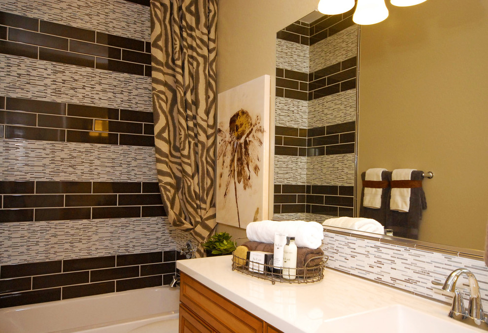 Example of a mid-sized trendy kids' black tile and ceramic tile ceramic tile bathroom design in Phoenix with a drop-in sink, raised-panel cabinets, medium tone wood cabinets, quartz countertops, a one-piece toilet and beige walls
