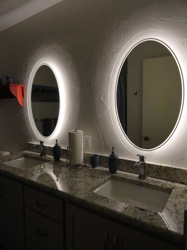 Cette image montre une petite salle de bain principale avec un lavabo encastré, un placard à porte affleurante, des portes de placard beiges, un plan de toilette en granite et un mur blanc.
