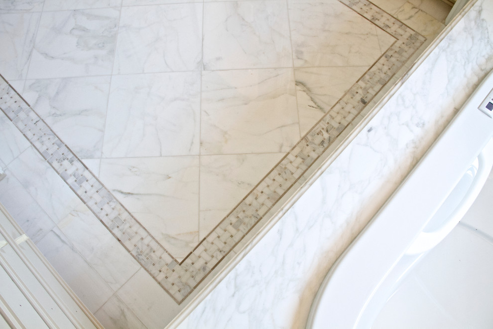Cette image montre une grande salle de bain principale design avec un plan de toilette en marbre, une baignoire posée, un carrelage blanc, un carrelage de pierre et un sol en marbre.