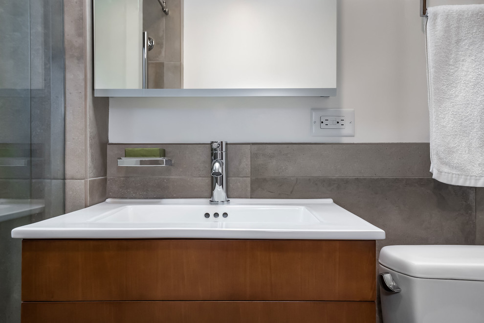 Small minimalist beige tile and porcelain tile porcelain tile and beige floor bathroom photo in Other with shaker cabinets, medium tone wood cabinets, a one-piece toilet, white walls and a wall-mount sink