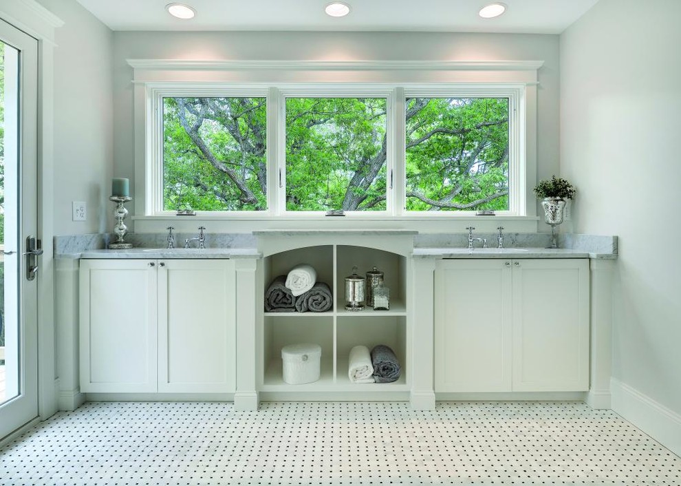 Idée de décoration pour une salle de bain principale tradition de taille moyenne avec un placard à porte shaker, des portes de placard blanches, un mur gris, un sol en marbre, un lavabo encastré, un plan de toilette en marbre et un sol blanc.
