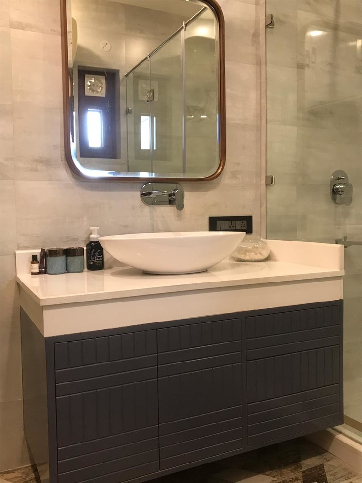 Inspiration for a medium sized classic ensuite bathroom in Sydney with grey walls, ceramic flooring, brown floors, freestanding cabinets, blue cabinets, a freestanding bath, a shower/bath combination, a wall mounted toilet, grey tiles, ceramic tiles, a console sink, marble worktops, a hinged door and white worktops.