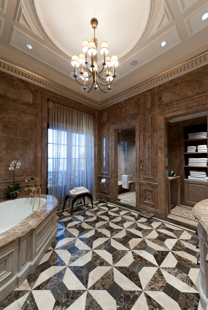 Inspiration för stora klassiska en-suite badrum, med ett undermonterat badkar, brun kakel, stenhäll, bruna väggar, marmorgolv och marmorbänkskiva