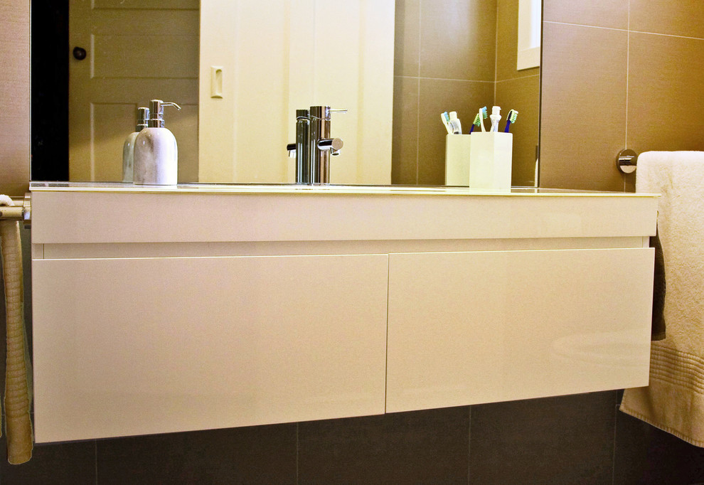 На фото: маленькая главная ванная комната в современном стиле с врезной раковиной, плоскими фасадами, белыми фасадами, стеклянной столешницей, двойным душем, инсталляцией, серой плиткой, керамической плиткой, серыми стенами и полом из керамической плитки для на участке и в саду с
