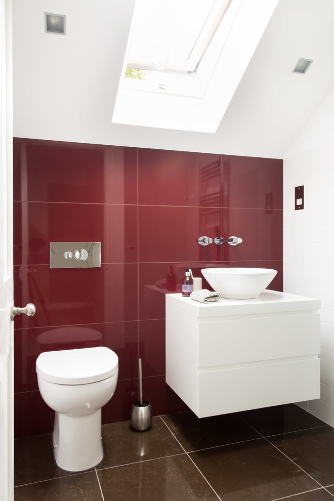 Example of a small trendy red tile and ceramic tile ceramic tile and brown floor bathroom design in Other with a vessel sink, a one-piece toilet, flat-panel cabinets, white cabinets, red walls and white countertops