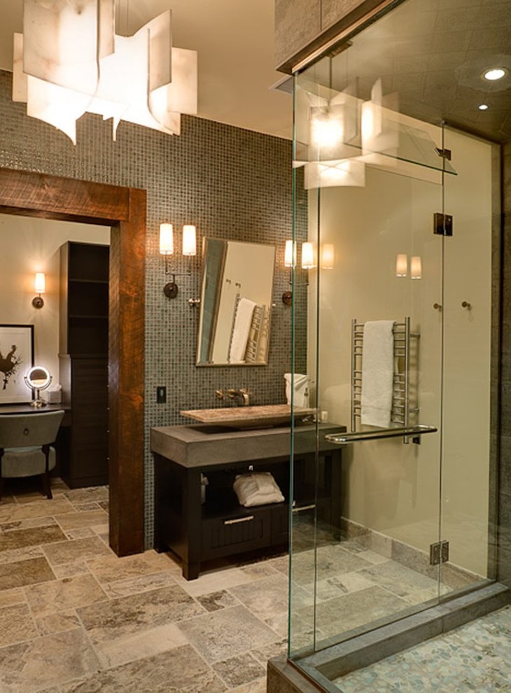 Inspiration for a large classic ensuite bathroom in Denver with flat-panel cabinets, black cabinets, concrete worktops, a corner shower, grey tiles, glass tiles, beige walls and limestone flooring.