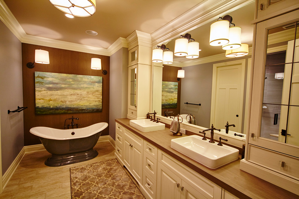 Mittelgroßes Klassisches Badezimmer En Suite mit profilierten Schrankfronten, weißen Schränken, freistehender Badewanne, lila Wandfarbe, Aufsatzwaschbecken und Waschtisch aus Holz in Indianapolis
