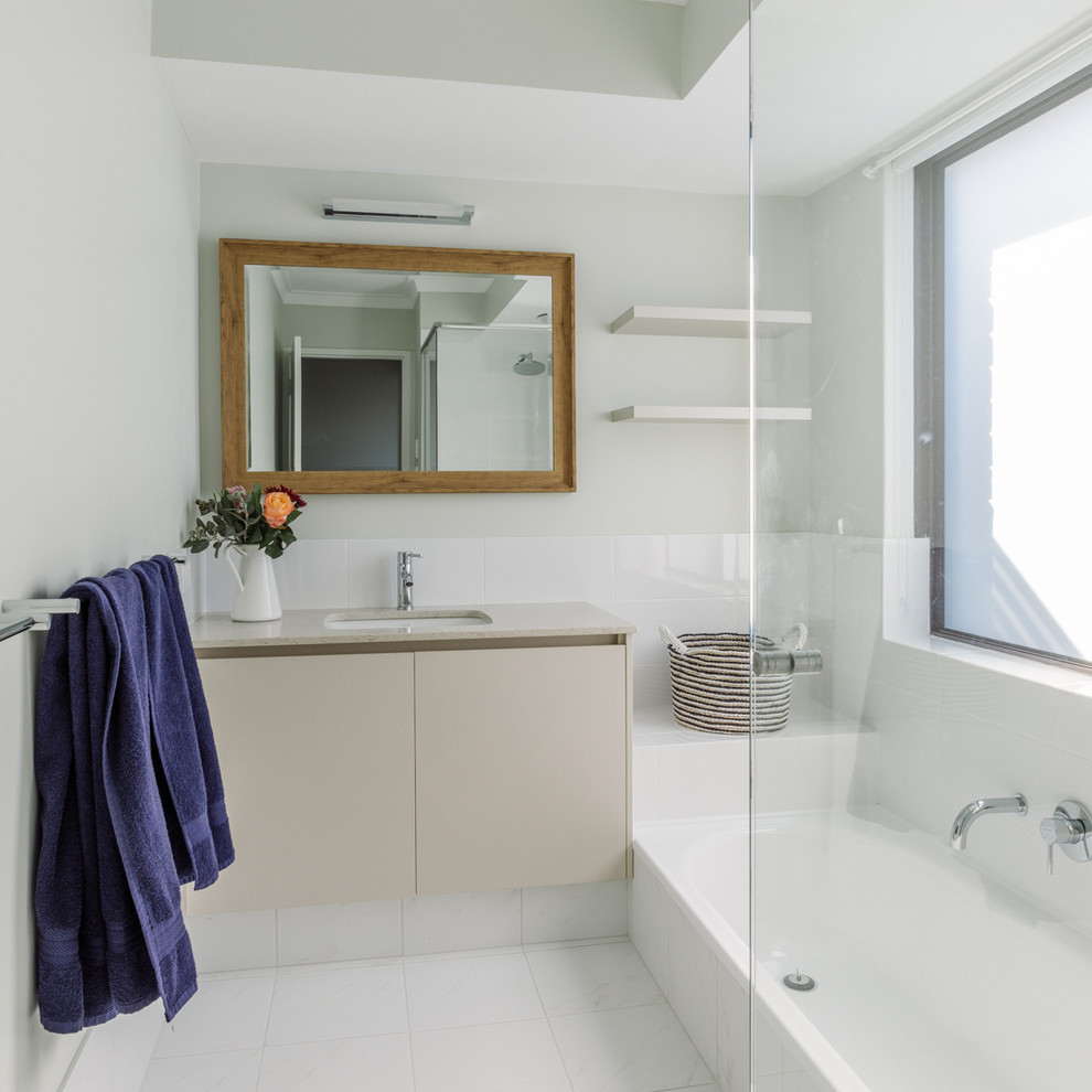 Modernes Badezimmer mit flächenbündigen Schrankfronten, beigen Schränken, Einbaubadewanne, bodengleicher Dusche, weißen Fliesen, weißer Wandfarbe, weißem Boden und offener Dusche in Perth