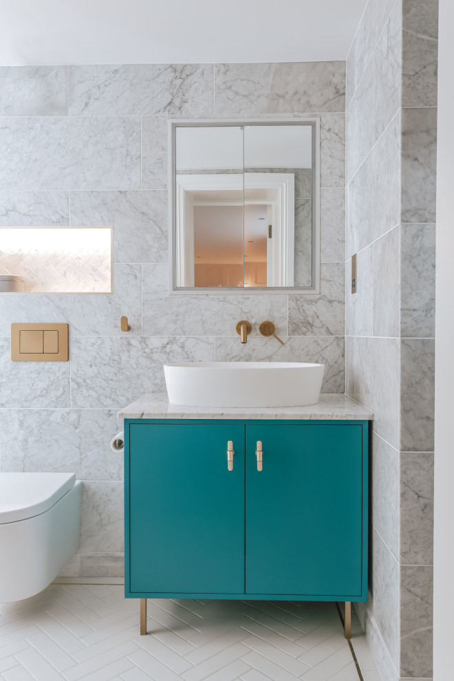 Modern inredning av ett stort grå grått en-suite badrum, med släta luckor, turkosa skåp, en öppen dusch, en vägghängd toalettstol, grå kakel, keramikplattor, grå väggar, klinkergolv i keramik, ett fristående handfat, marmorbänkskiva, vitt golv och med dusch som är öppen