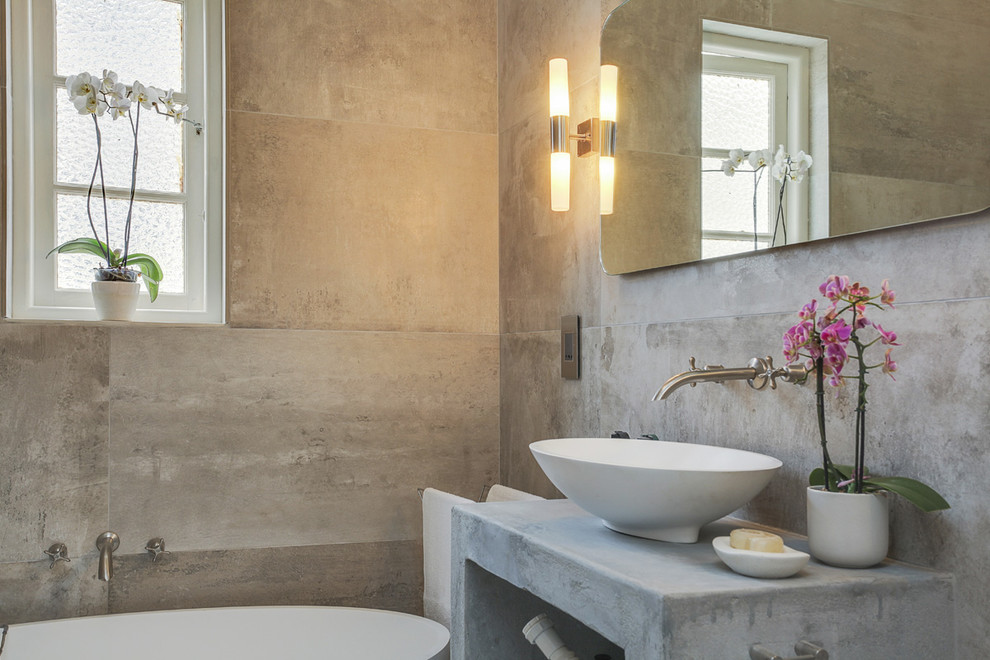 Immagine di una piccola stanza da bagno con doccia contemporanea con vasca freestanding, piastrelle grigie, piastrelle di cemento, pareti grigie, pavimento in cemento e top in cemento