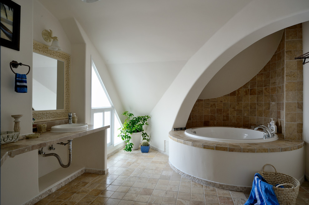 Design ideas for a mediterranean bathroom in Hong Kong with a vessel sink, beige tiles and a built-in bath.