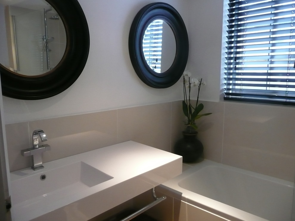 Example of a trendy beige tile and porcelain tile porcelain tile bathroom design in Other with a one-piece toilet, white walls and a wall-mount sink