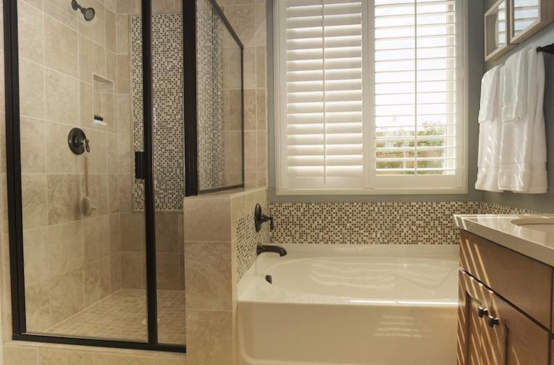 Пример оригинального дизайна: маленькая главная ванная комната в стиле неоклассика (современная классика) с фасадами в стиле шейкер, фасадами цвета дерева среднего тона, угловой ванной, угловым душем, бежевой плиткой, серой плиткой, белой плиткой, стеклянной плиткой, серыми стенами, врезной раковиной, столешницей из искусственного кварца, душем с распашными дверями и белой столешницей для на участке и в саду