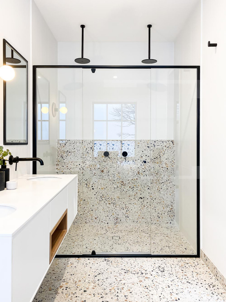 Inspiration for a contemporary shower room bathroom in Melbourne with flat-panel cabinets, white cabinets, a built-in shower, grey tiles, white walls, a submerged sink, grey floors, a sliding door, white worktops, double sinks and a floating vanity unit.