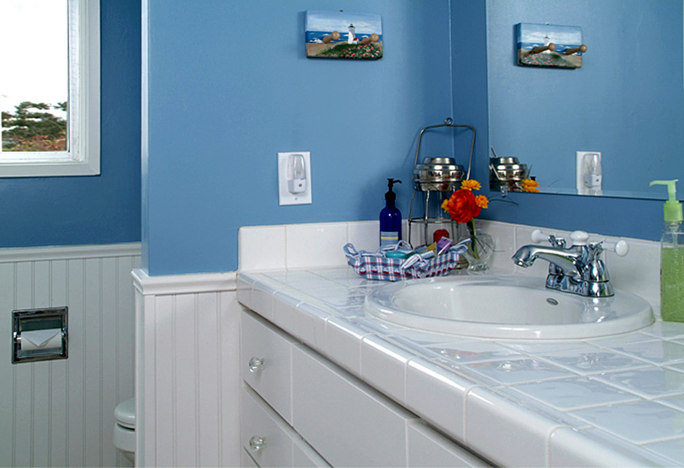 Mittelgroßes Klassisches Duschbad mit weißen Schränken, gefliestem Waschtisch, Einbaubadewanne, Toilette mit Aufsatzspülkasten, Keramikfliesen, blauer Wandfarbe, Keramikboden, flächenbündigen Schrankfronten, weißen Fliesen und Unterbauwaschbecken in San Diego