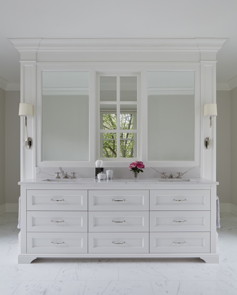 Foto de cuarto de baño principal clásico renovado con puertas de armario blancas, suelo de mármol, lavabo bajoencimera, encimera de mármol y suelo blanco