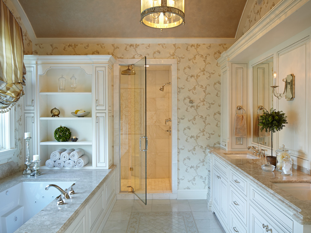 Идея дизайна: главная ванная комната среднего размера в классическом стиле с белыми фасадами, мраморной столешницей, полновстраиваемой ванной, двойным душем, бежевой плиткой, каменной плиткой, мраморным полом и фасадами с выступающей филенкой