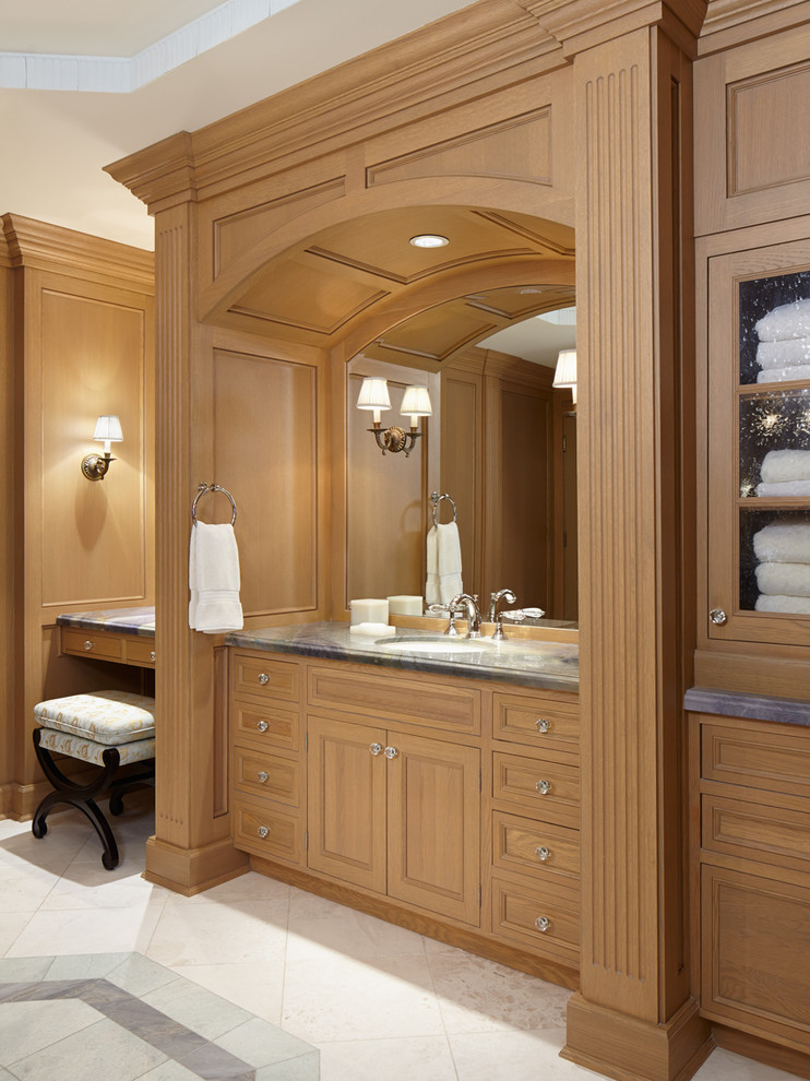 Aménagement d'une salle de bain principale classique en bois brun de taille moyenne avec un placard à porte affleurante, un plan de toilette en marbre, un carrelage beige et un sol en marbre.