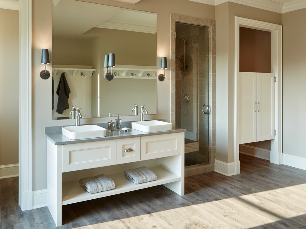 Diseño de cuarto de baño clásico renovado con puertas de armario blancas, lavabo sobreencimera y encimera de cuarzo compacto
