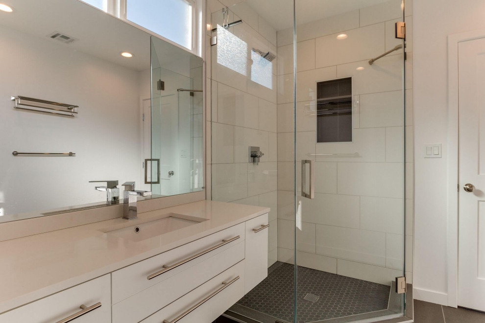 Idéer för små funkis vitt en-suite badrum, med släta luckor, vita skåp, en toalettstol med hel cisternkåpa, vit kakel, porslinskakel, vita väggar, klinkergolv i porslin, ett nedsänkt handfat, bänkskiva i kvarts, grått golv och dusch med duschdraperi