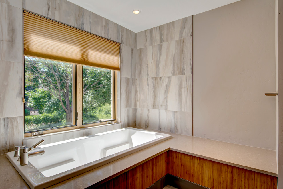 На фото: большая главная ванная комната в современном стиле с плоскими фасадами, светлыми деревянными фасадами, накладной ванной, душем в нише, серой плиткой, каменной плиткой, серыми стенами, полом из керамогранита, накладной раковиной и столешницей из гранита с
