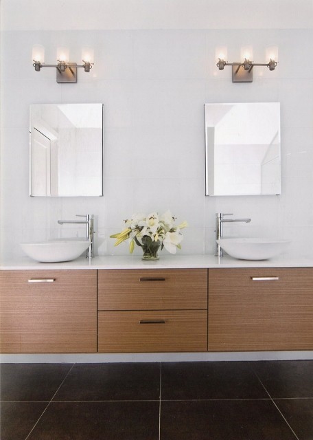 Modelo de cuarto de baño principal moderno grande con armarios con paneles lisos, puertas de armario de madera oscura, baldosas y/o azulejos blancos, paredes blancas, lavabo sobreencimera y encimera de cuarcita