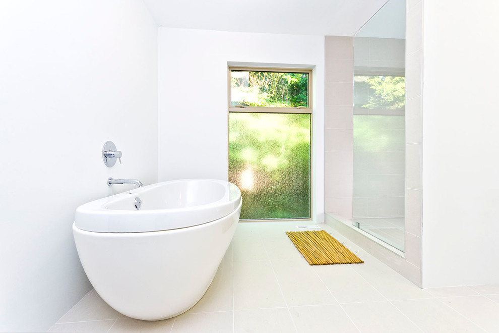 Imagen de cuarto de baño minimalista pequeño con bañera exenta, ducha empotrada, paredes blancas y suelo de travertino