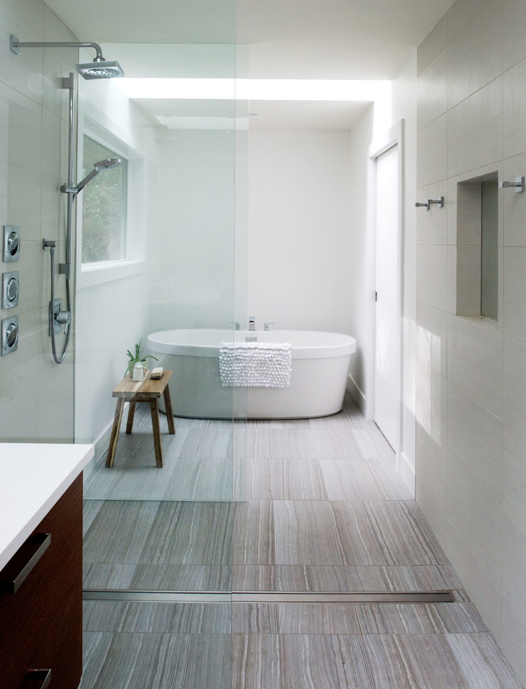 Inredning av ett klassiskt badrum, med släta luckor, skåp i mörkt trä, ett fristående badkar, en öppen dusch, vita väggar och med dusch som är öppen