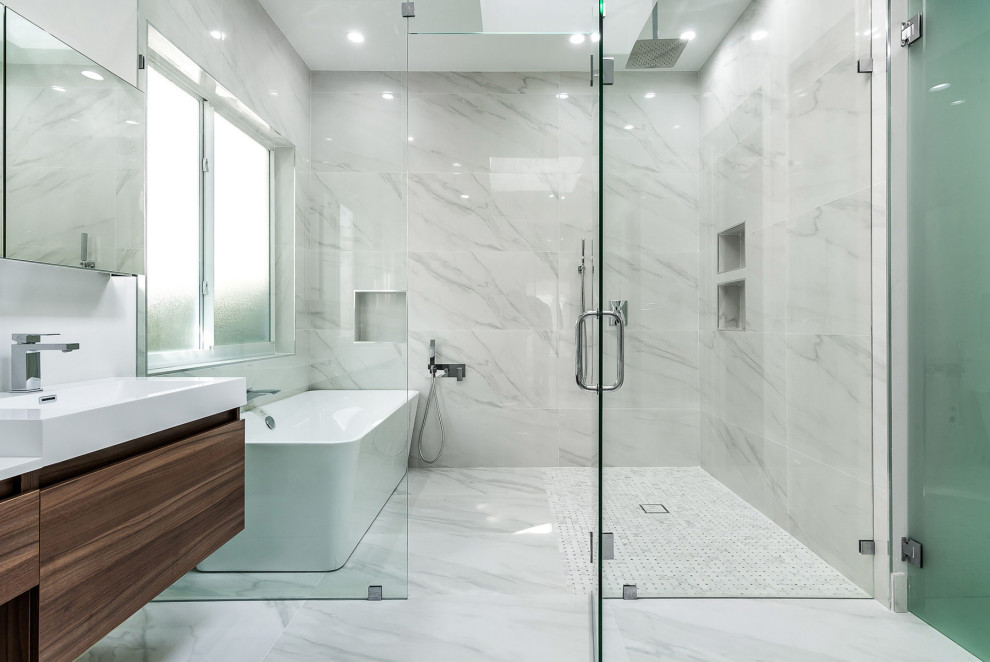 Inspiration for a contemporary ensuite wet room bathroom in Miami with flat-panel cabinets, medium wood cabinets, a freestanding bath, grey tiles, white tiles, white walls, marble flooring, an integrated sink, multi-coloured floors, a hinged door and white worktops.
