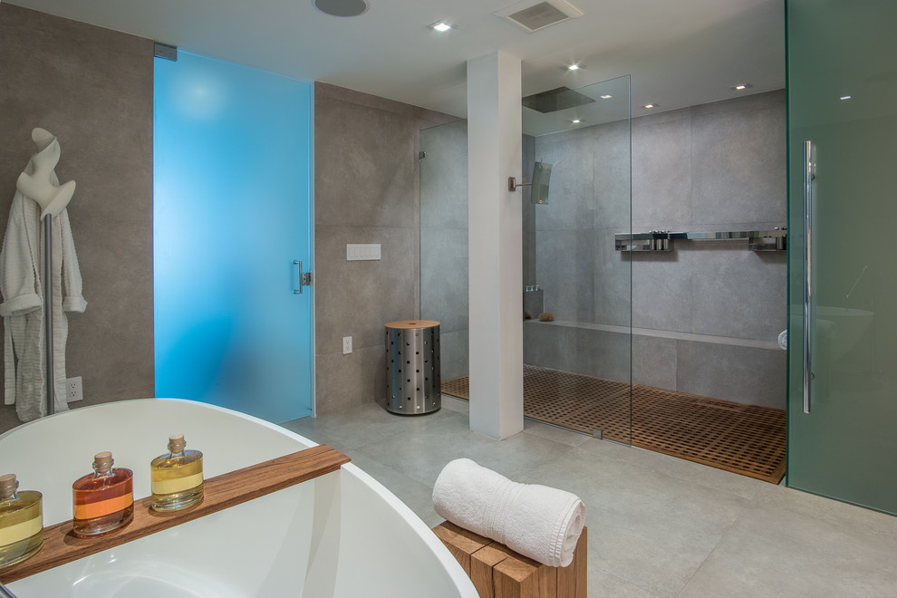 Immagine di una stanza da bagno contemporanea con vasca freestanding, doccia alcova e piastrelle grigie