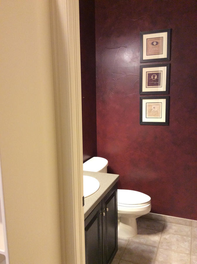 Foto di un piccolo bagno di servizio tradizionale con ante con bugna sagomata, ante in legno bruno, pareti rosse, pavimento in travertino e top in superficie solida