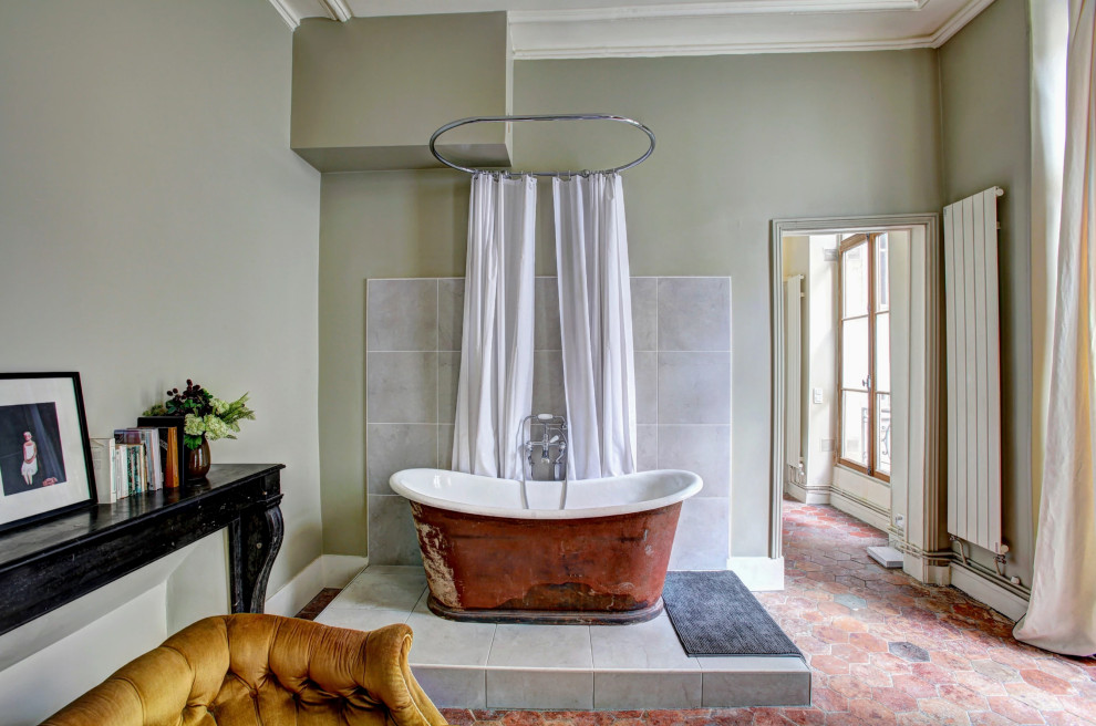 Exempel på ett klassiskt badrum, med ett fristående badkar, grå kakel, gröna väggar och rött golv