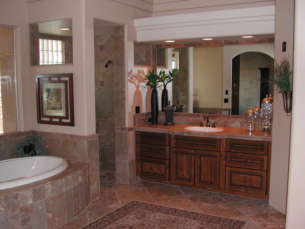 Klassisk inredning av ett mellanstort en-suite badrum, med ett nedsänkt handfat, luckor med upphöjd panel, skåp i mörkt trä, granitbänkskiva, ett platsbyggt badkar, en öppen dusch, beige kakel, stenkakel, beige väggar och travertin golv