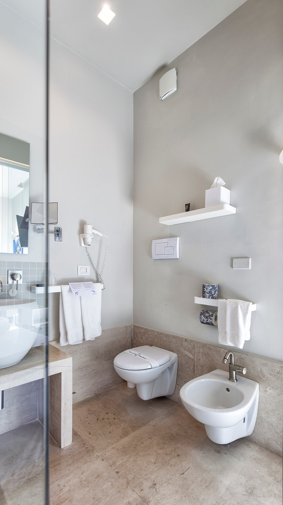 Idee per una stanza da bagno moderna con WC sospeso, lastra di pietra, pareti grigie e lavabo a bacinella