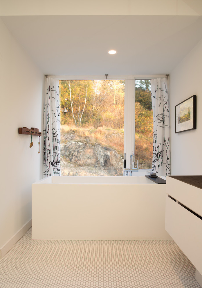 Modernes Badezimmer mit flächenbündigen Schrankfronten, weißen Schränken, freistehender Badewanne, weißer Wandfarbe und Mosaik-Bodenfliesen in Sonstige