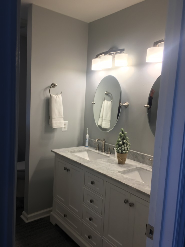 Idéer för mellanstora vintage en-suite badrum, med luckor med infälld panel, vita skåp, en dusch i en alkov, en toalettstol med separat cisternkåpa, grå väggar, vinylgolv, ett undermonterad handfat, marmorbänkskiva, grått golv och dusch med gångjärnsdörr