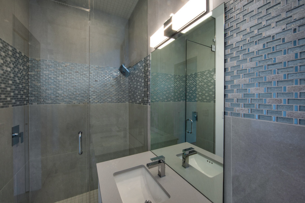 Cette image montre une très grande salle de bain minimaliste avec un placard à porte plane, des portes de placard marrons et un plan de toilette blanc.