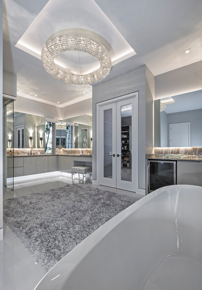 Contemporary bathroom in Miami with flat-panel cabinets, beige cabinets, a freestanding bath, a corner shower, a one-piece toilet, granite worktops, a hinged door and beige worktops.
