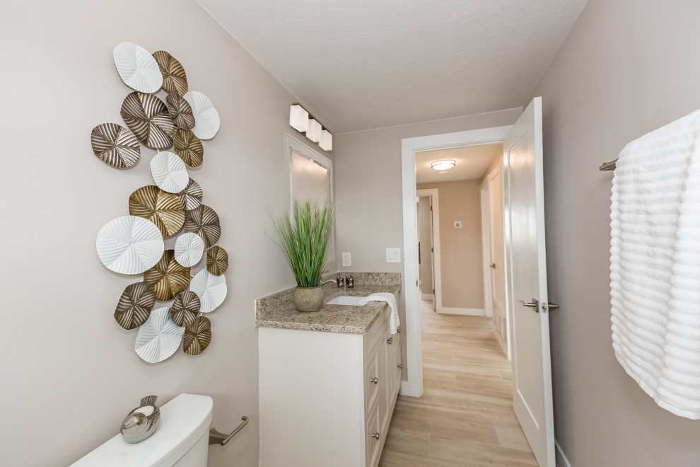 Large modern bathroom in Tampa with raised-panel cabinets, white cabinets, a shower/bath combination, white tiles, marble tiles, grey walls, porcelain flooring, a submerged sink, granite worktops, beige floors, an open shower and brown worktops.