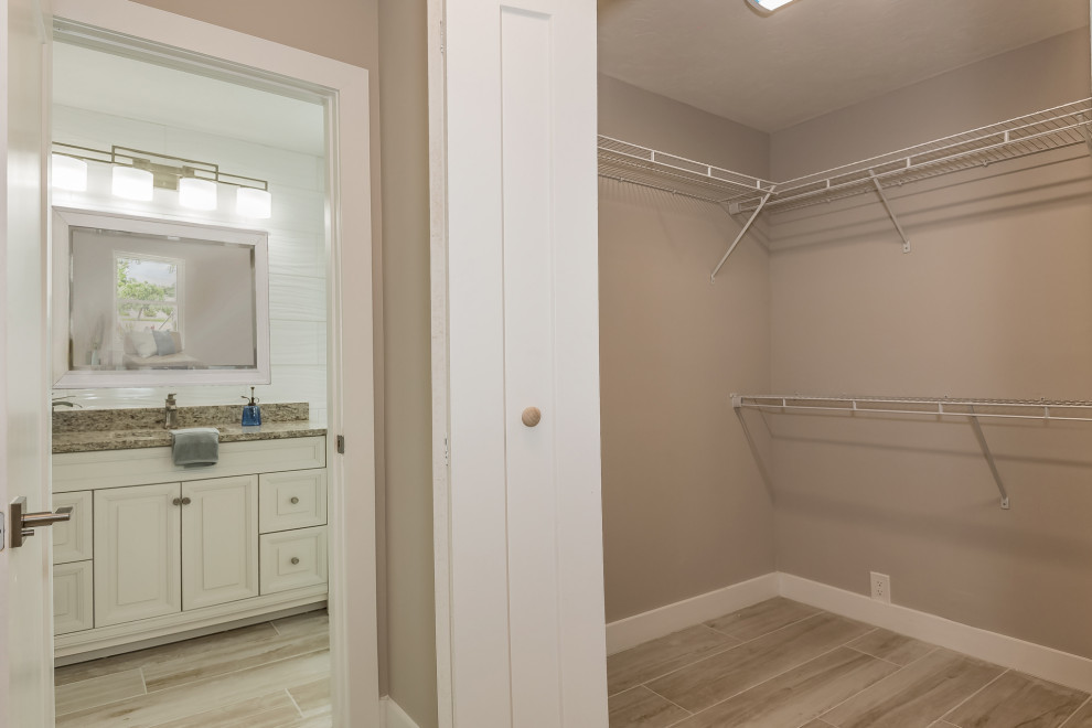 Aménagement d'une salle de bain moderne de taille moyenne avec un placard avec porte à panneau surélevé, un carrelage blanc, des carreaux de céramique, un mur blanc, un sol en carrelage de porcelaine, un plan de toilette en granite, un sol beige et un plan de toilette marron.