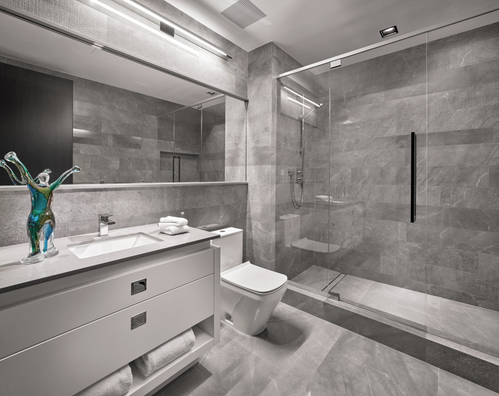 Modernes Duschbad mit flächenbündigen Schrankfronten, grauen Schränken, Duschnische, grauen Fliesen, Unterbauwaschbecken, grauem Boden, grauer Waschtischplatte, Einzelwaschbecken und eingebautem Waschtisch in Miami