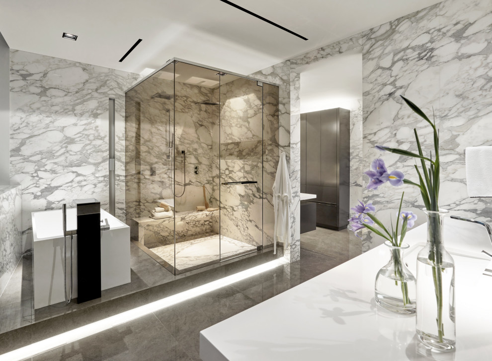 Inredning av ett modernt vit vitt badrum, med ett fristående badkar, en hörndusch, grå kakel, ett undermonterad handfat, grått golv och dusch med gångjärnsdörr